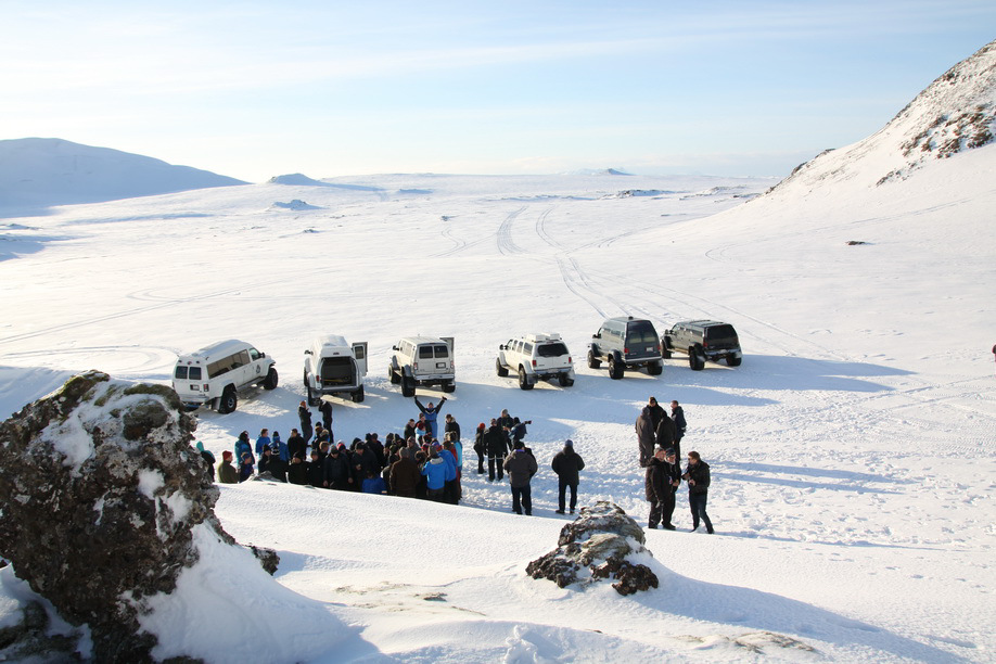 Sju super jeeper parkert i en rekke på snøen med en stor gruppe mennesker foran
